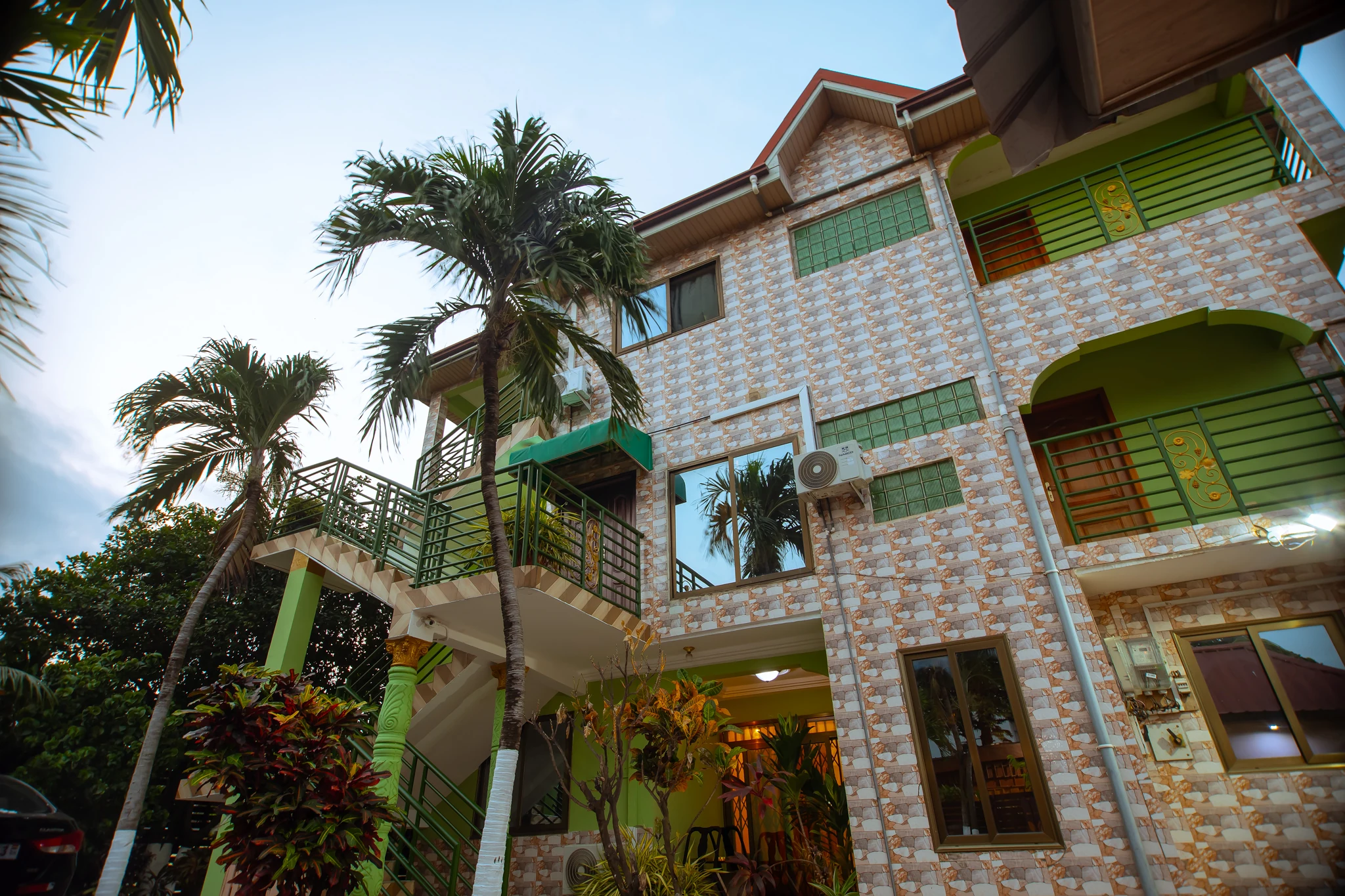 Exterior of a TandohStay cottage in Ghana with greenery and a paved driveway